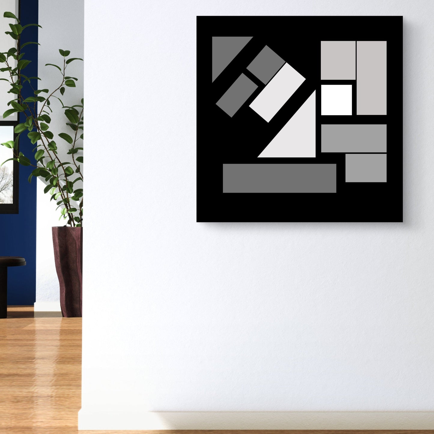 Abstract monotonic geometric artwork on a white wall with a plant to the left.